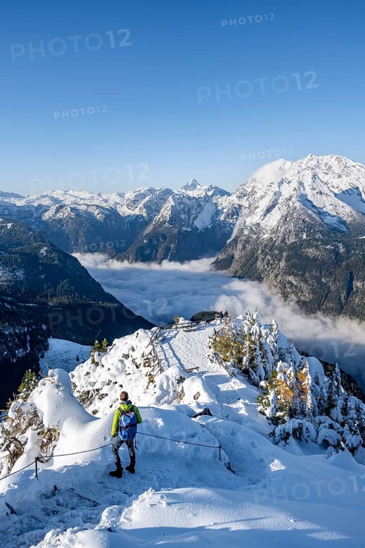 Tourist on a hiking trail, Snow-covered summit of the Jenner with viewing platform in autumn, view of the sea of clouds and Watzmann, Berchtesgaden National Park, Berchtesgaden Alps, Schönau am Königssee, Berchtesgadener Land, Bavaria, Germany, Europe