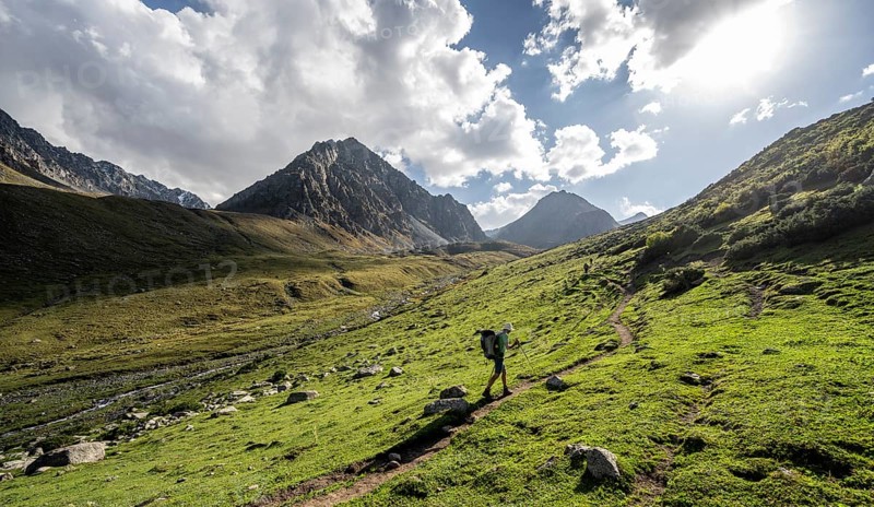 Mountaineers on a hiking trail, green high valley with mountain stream, Keldike Valley on the way to the Ala Kul Pass, Tien Shan Mountains, Kyrgyzstan, Asia