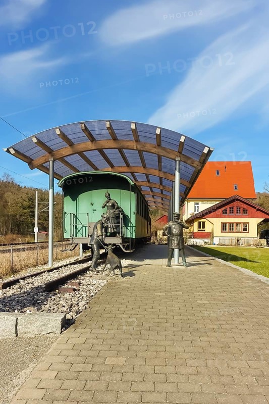 Durlesbach railway station, opened in 1849 and decommissioned in 1984, railway monument, railway memorial, group of figures by the artist René Auer, group of sculptures, scene from the song Auf de schwäbische Eisebahne, billy goat, woman, farmer, conductor, s Bäuerle, Konduktör, s Weible, bronze figures, Königlich Württembergischen Staats-Eisenbahnen, station building at the back right, Durlesbach, Reute, Bad forest lake, Upper Swabia, Baden-Württemberg, Germany, Europe