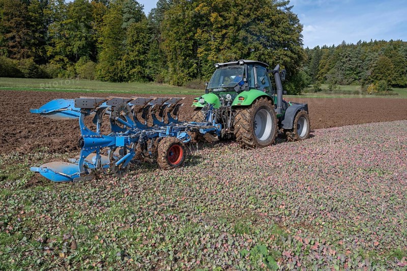 Farmer with tractor ploughing his field with a 5-turn rotary plough, Franconia, Bavaria, Germany, Europe