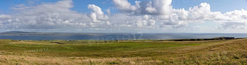 Panoramic view over wide meadows to the distant sea, Cliffs of Moher