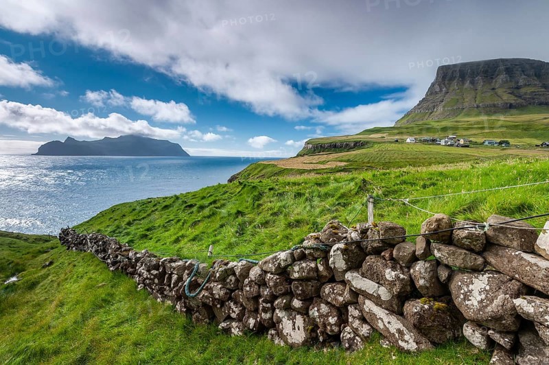 View of the island of Mykines, old stone wall, Gásadalur village, Vágar, Faroe Islands, Denmark, Europe