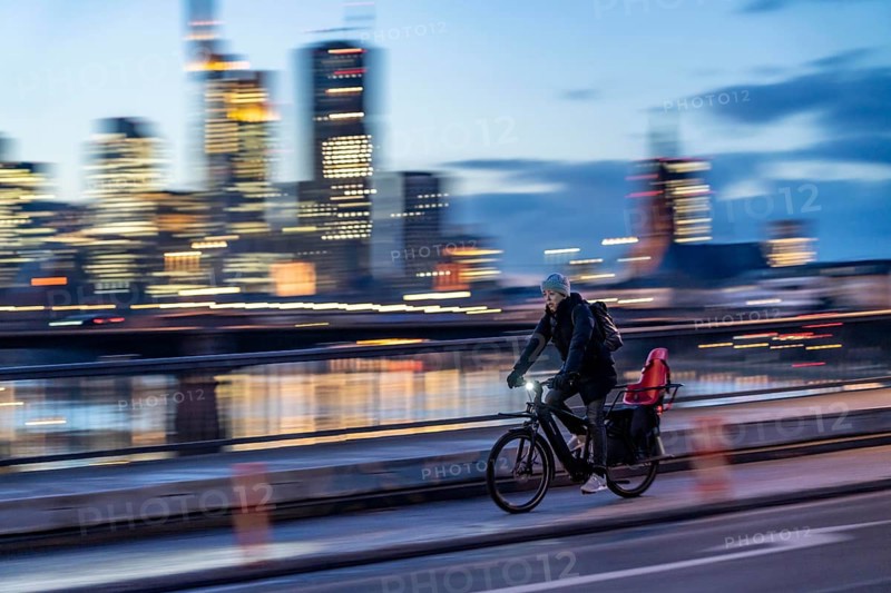Skyline of the city centre of Frankfurt am Main, cyclist on the raft bridge, dusk, river Main, winter, Hesse, Germany, Europe
