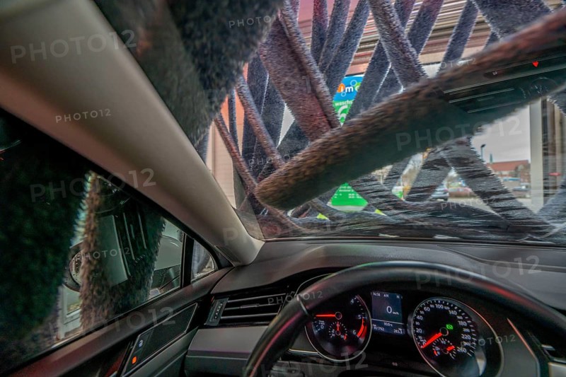 Car in an automatic car wash, car wash tunnel, vehicle drying after washing with warm compressed air and drying cloths