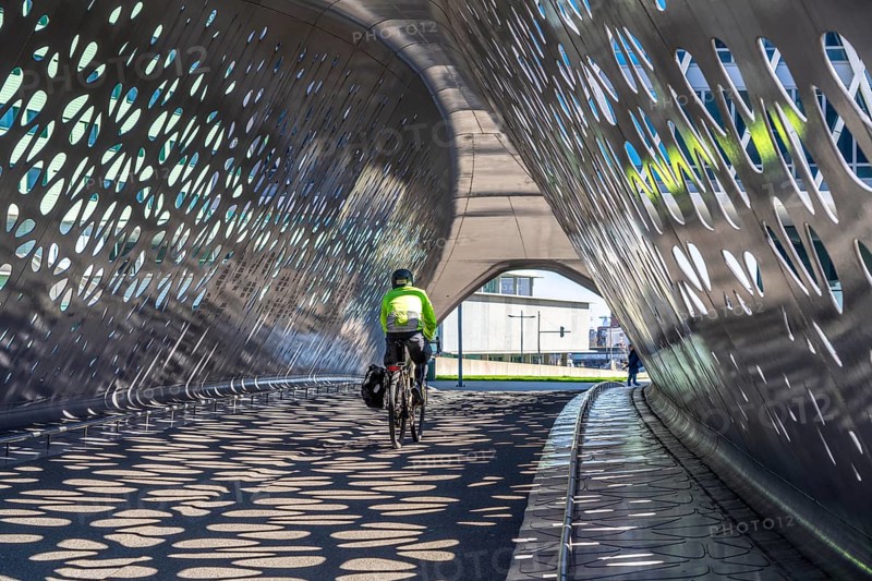 Light effects from the sun in the Parkbruk, a cycle and pedestrian bridge in the city centre of Antwerp, spanning a multi-lane city centre road with tram lines, and thus connecting two lively city districts Kop Spoor Noord and Eilandje, Belgium, without any crossings, Europe