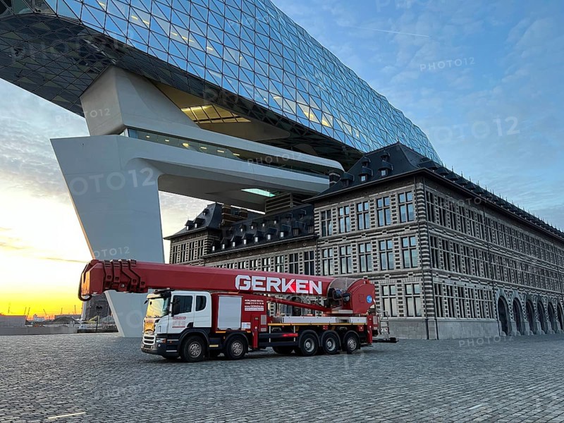 Building cleaners cleaning window panes, cleaning a facade, lorry working platform of the German rental company Gerken, the Antwerp Port Authority building, Havenhuis, former fire brigade barracks in the harbour, renovated and with an attached glass structure, in the shape of a ship's hull, administrative headquarters of the Antwerp Port Authority, designed by Zaha Hadid, Antwerp, Flanders, Belgium, Europe