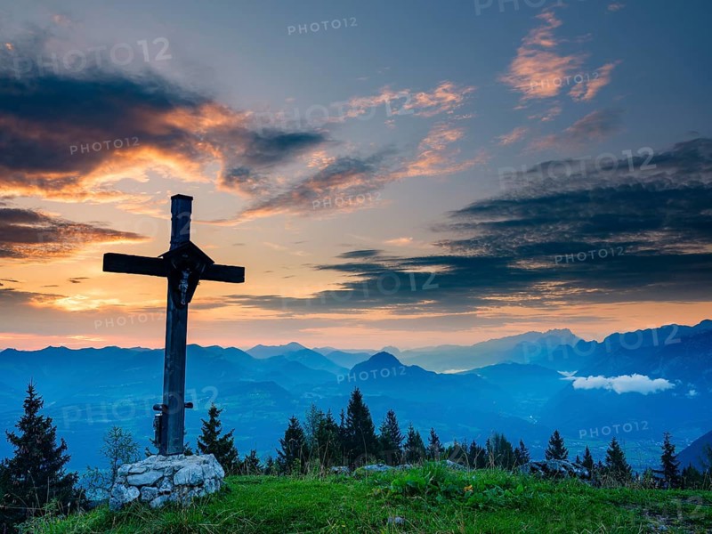 Summit cross of the Ahornbüchsenkopf at dawn, behind Osterhorngruppe and Dachstein, Roßfeld, Berchtesgaden, Berchtesgadener Land, Upper Bavaria, Bavaria, Germany, Europe