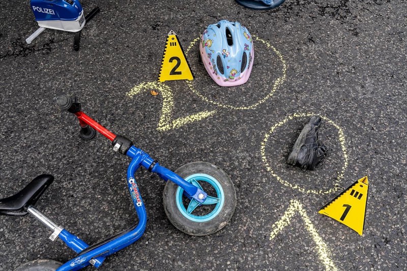 Markings at an accident scene with a balance bike for children, helmet, reenacted accident recording, at a public event organised by the Cologne police, symbolic image