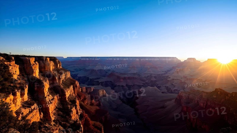 Sunrise over grand canyon in vibrant colors casting light on overhanging rock formations, AI generated