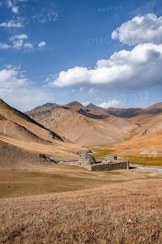 Historic caravanserai Tash Rabat from the 15th century, with yellow hills, Atbashy district in the Naryn region, Kyrgyzstan, Asia