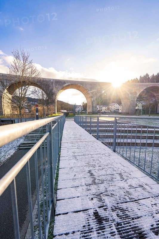 Wooden walkway with snow under a viaduct at dusk, with clear sky and bright light, forest ball from Landesgartenschau 2012, Nagold, Black Forest, Germany, Europe