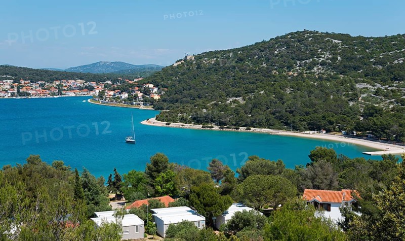 Coastal town with pine trees and sailing boats, surrounded by blue sea, bay near Tisno, Šibenik-Knin, Sibenik, Croatia, Europe