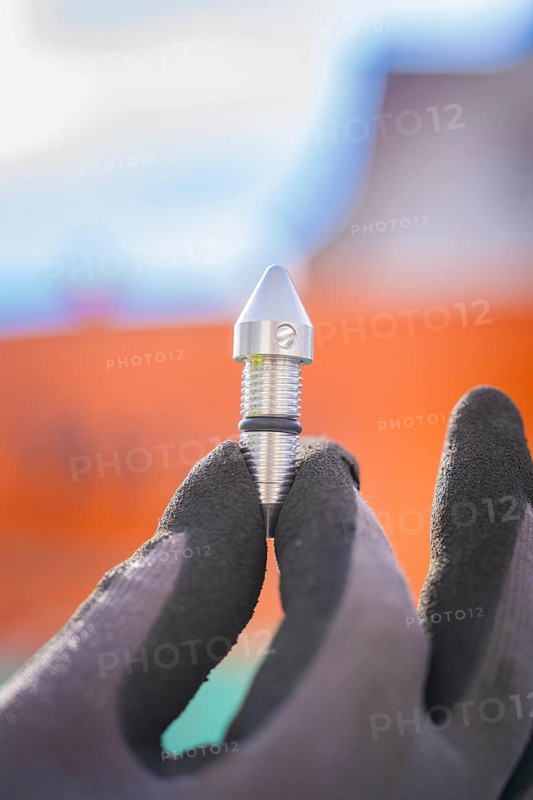 Metal component in gloved hand outdoors, Wend Glasfasermontage during jetting of conduits for fibre optic cables, Meßkirch, district of Sigmaringen, Germany, Europe