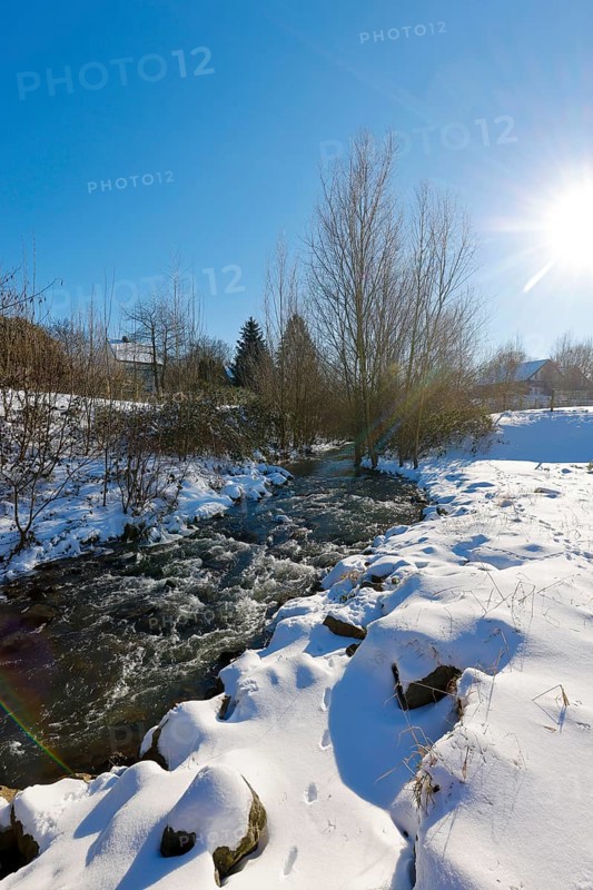 Dortmund, North Rhine-Westphalia, Germany - Sunny winter landscape in the Ruhr area, ice and snow on the renaturalised Emscher, the ecological conversion of the Emscher system consists of the construction of a central wastewater treatment system in the Ruhr area, the construction of underground sewers and the renaturalisation of the Emscher and its tributaries