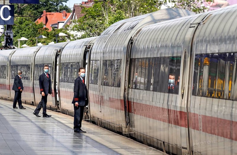 Deutsche Bahn train attendants wear face masks shortly in front of the departure of an ICE train at Berlin Spandau station, 27/05/2020