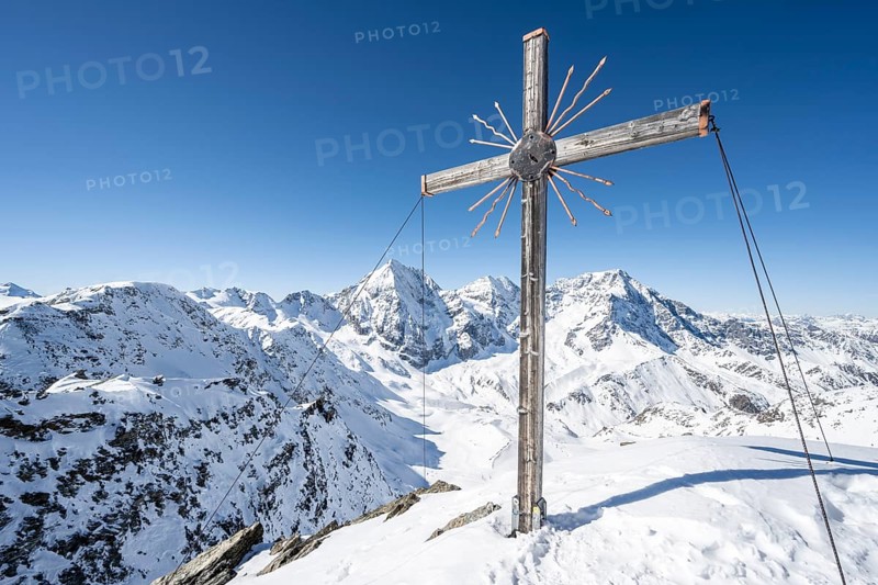 Summit cross at the summit of the Madritschspitze, mountain panorama with snow-covered mountain landscape in winter, view of mountain peaks Königsspitze, Monte Zebru and Ortler, Ortler Alps, Vinschgau Valley, Italy, Europe