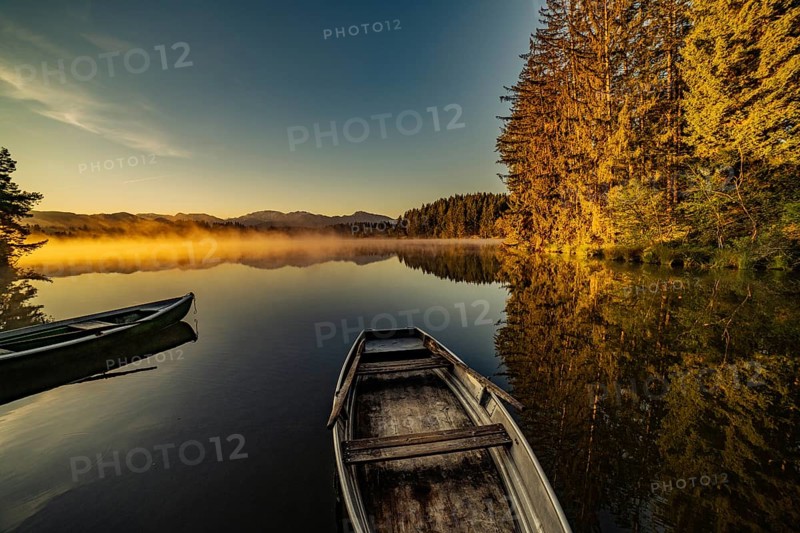 Boats in the autumnal Schmutter Weiher in the Allgäu near the municipalities of Halblech, Roßhaupten and Lechbruck in Ostallgäu in the foothills of the Alps