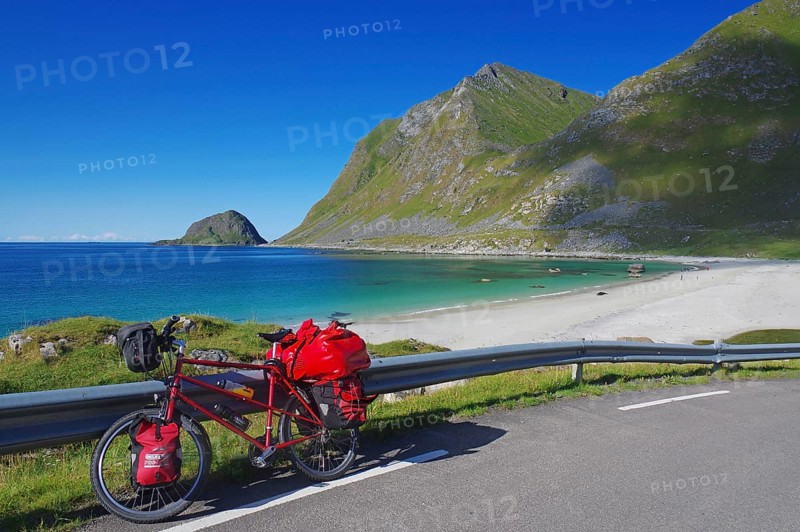 Loaded bicycle on a road with a view of a long dream beach and the sea, cycle tourism, cycle tours, Haukland, Lofoten, Nordland, Norway, Europe