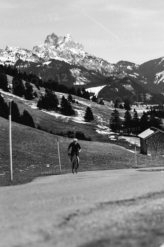 Road bike rider in spring in the Allgäu against the picturesque backdrop of the Alps, Bavaria, Germany, Europe