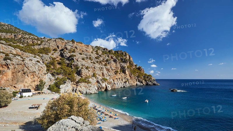 Panorama of a rocky coastline with beach and offshore boats under a blue sky, Ahata Beach, Ahata, east coast, Karpathos, Dodecanese, Greek Islands, Greece, Europe