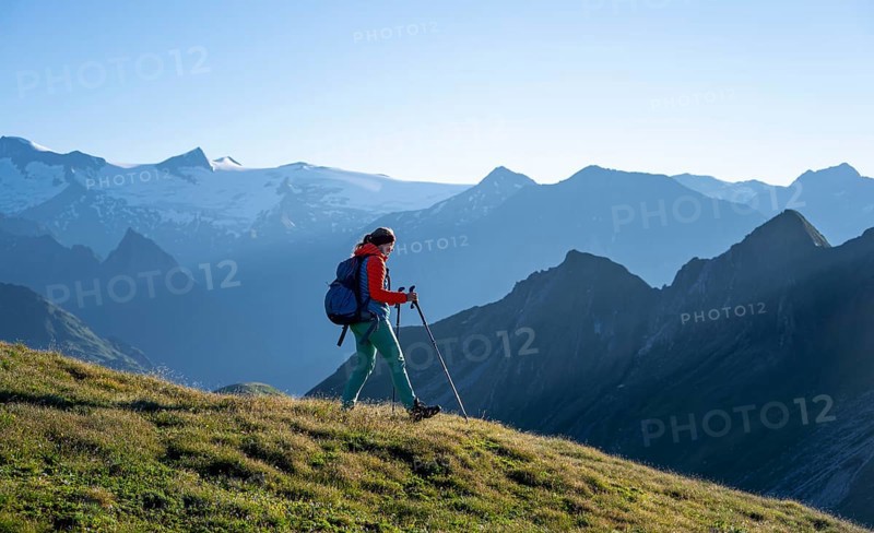 Hiker enjoying the mountain panorama in the morning, Venediger group, behind Dreiherrenkopf, Simonysitze and Großer Geiger, Hohen Tauern, Austria, Europe
