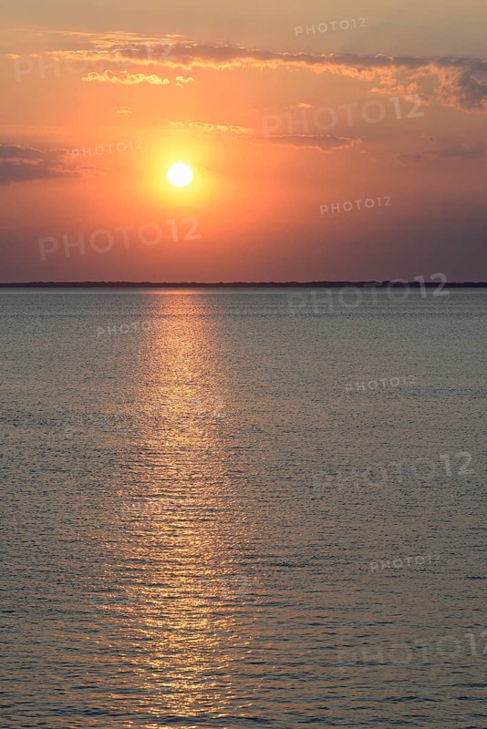 Sunset over the calm North Sea, the outline of the island of Juist on the horizon, Norddeich, Lower Saxony, Germany, Europe