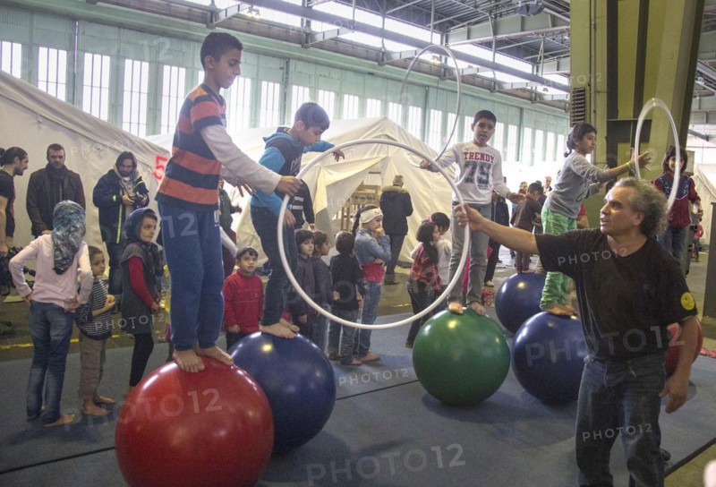 Children of refugees playing between tents in an emergency shelter for refugees on 9 December 2015 in the former hangar of Tempelhof Airport, Berlin, Berlin, Germany, Europe