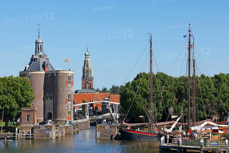 Town view of Enkhuizen with harbour entrance and historic old town with defence tower of Drommedaris, former defence tower, and tower of Zuiderkerk church behind, Enkhuizen, North Holland, West Friesland, Netherlands