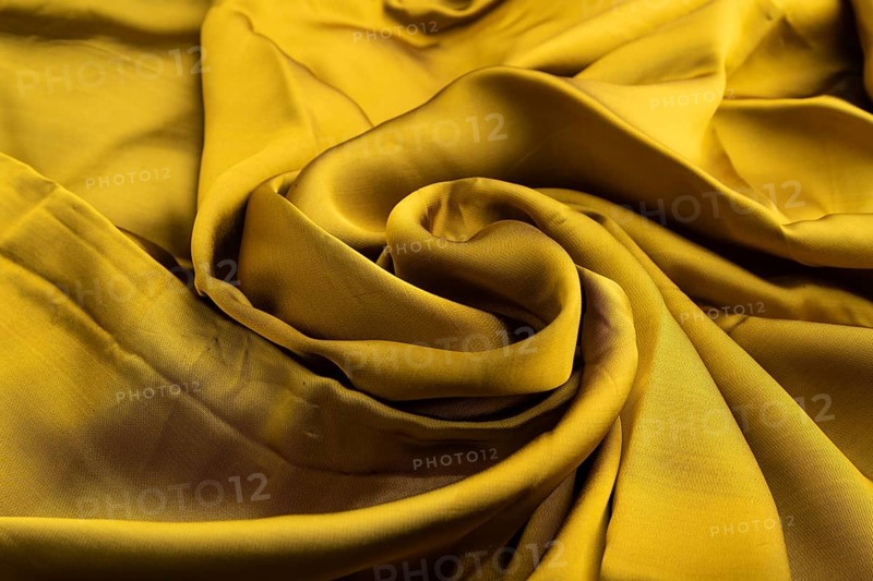 Fragment of yellow and green tissue. Side view, synthetic textile background and texture. wave concept, abstract