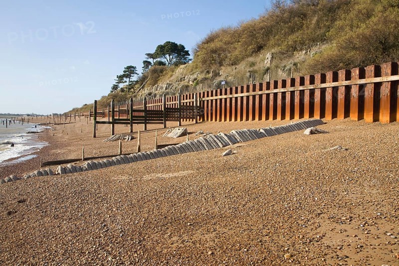 Rusty steel piling sea wall defences and shingle beach near Bawdsey Quay, Suffolk, England, United Kingdom, Europe