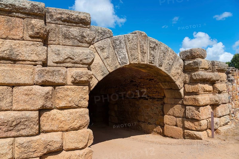Historic stone archway from Roman times, surrounded by thick stone walls under a blue sky, Mérida, Merida, Badajoz, Extremadura, Spain, UNESCO World Heritage Site, Europe