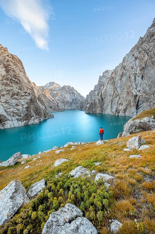 Young man at the turquoise mountain lake Kol Suu with rocky steep mountains, Kol Suu Lake, Sary Beles Mountains, Naryn Province, Kyrgyzstan, Asia