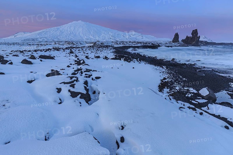 Rocks, lava field and surf at the coast, evening light, sun, snow, winter, Arnarstapi, Snaefellsjökull, Snaefellsnes, Vesturland, Iceland, Europe