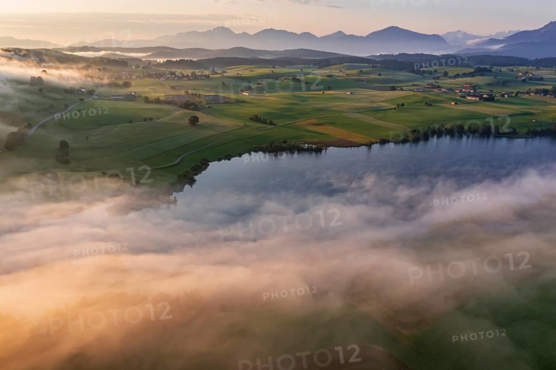 Aerial view of a lake in front of mountains in the morning light, fog, autumn, Riegsee, view of Benediktenwand and Joch, Alpine foothills, Upper Bavaria, Bavaria, Germany, Europe