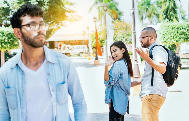 Distracted girlfriend looking at another man on the street. Unfaithful girlfriend looking at another man on the street, Unfaithful girl looking at another man on street and her boyfriend claims her