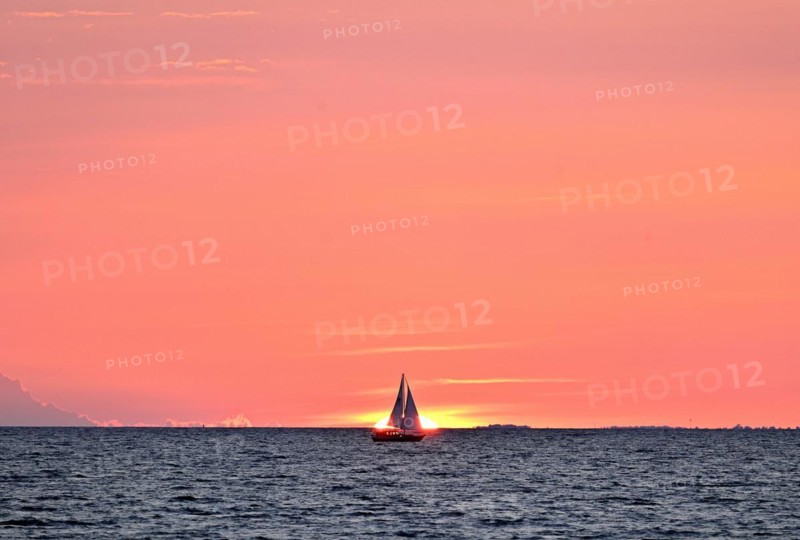 Sailboat sailing in the evening towards the setting sun, Baltic Sea, Poel Island, Mecklenburg-Western Pomerania, Germany, Europe