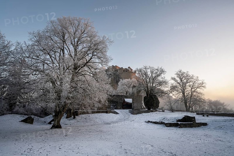 The snow-covered Karlsbastion of the Hohentwiel fortress ruins in front of sunrise on a cold winter morning, Singen am Hohentwiel, Constance district, Baden-Württemberg, Germany, Europe