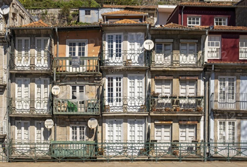 Front facades of narrow houses in the historic center near the Douro river in Porto, Portugal, Europe