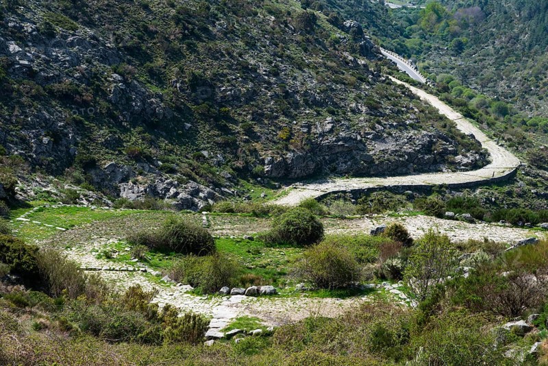 A winding path runs through a hilly and green landscape with rocky elevations, old Roman road, at the Puerto del Pico, Sierra de Gredos, Ávila, Avila, Castilla y León, Leon, Spain, Europe