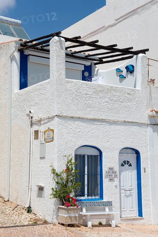White and blue Mediterranean house with flowers in front of a terrace under a clear sky, Albufeira, Faro, Algarve, Portugal, Europe