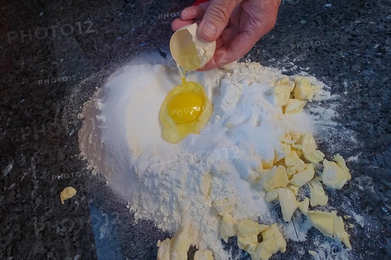 Swabian cuisine, Swabian Christmas biscuits, preparation of dough for Ausstecherle, shortcrust biscuits, raw egg in flour, butter, sugar mixture, typical Swabian, baking, Christmas biscuits, sweet biscuits, Gutsle, Bredle, baked goods, from the oven, men's hands, traditional cuisine, food photography, studio, Germany, Europe