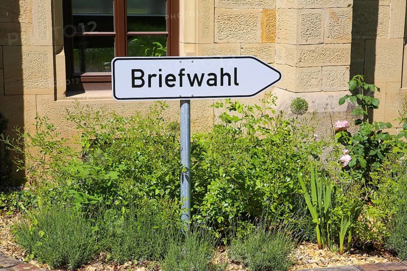 Postal voting sign, signpost for postal voting, writing, letters, information board, behind Varbülersches Schloss, Schloss Hemmingen, former seat of the barons of Varnbüler, main building today town hall, Hemmingen, Ludwigsburg district, Baden-Württemberg, Germany, Europe