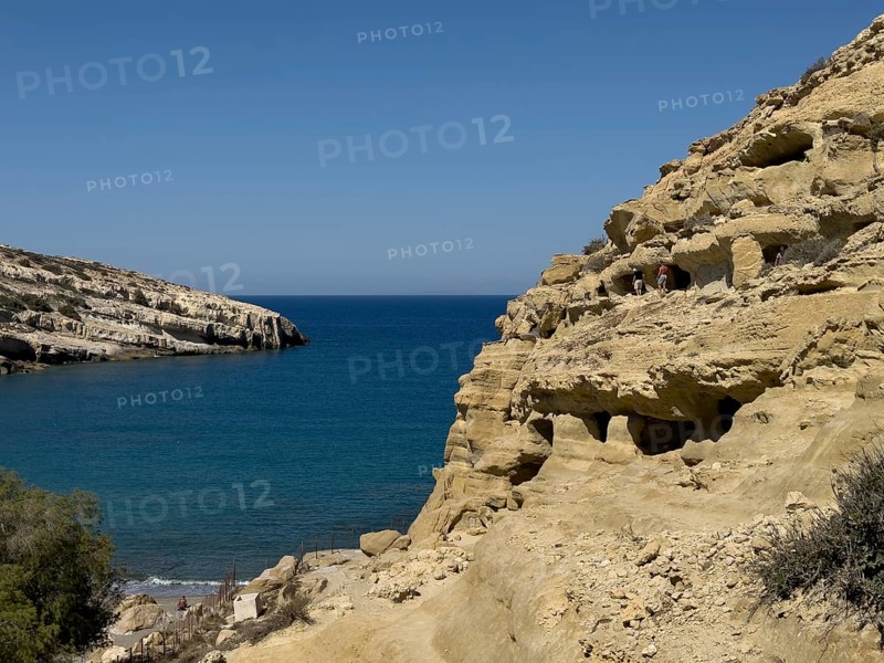 View of entrances of caves in sandstone rocks of former Roman necropolis with sandstone caves carved into sandstone Cave tombs Grottoes in rocks on the north side of Matala Bay, in the 60s and 70s hippie caves Caves for dropouts and hippies today excursion destination on the south coast of Crete island, left at the edge of the picture Libyan Sea Mediterranean, Matala, Crete, Greece, Europe