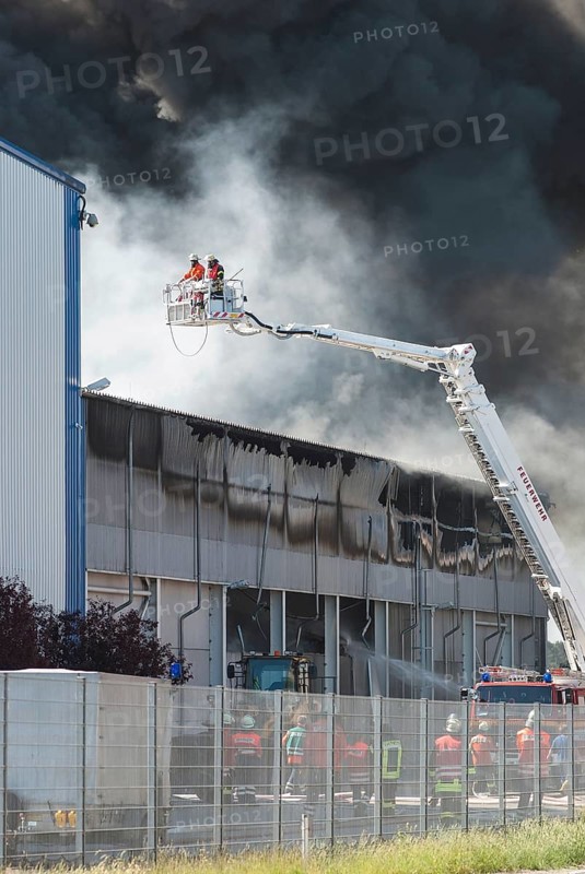 Firefighters, two firefighters with protective clothing and gas masks in aerial work platform, lifting platform on crane, smoke cloud of a large fire in an industrial building, Lower Saxony, Germany, Europe