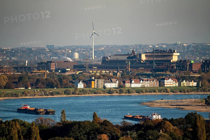 Cargo ships on the Rhine near Duisburg, houses on Deichstrasse, industrial backdrop of the ArcelorMittal Hochfeld GmbH steel wire plant, North Rhine-Westphalia, Germany, Europe