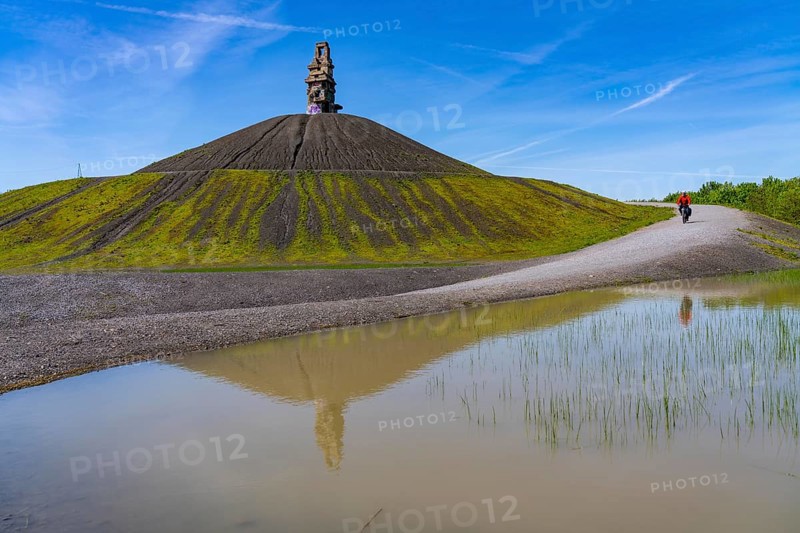Cyclist on the Rheinelbe spoil tip in Gelsenkirchen, 100 metre high spoil tip, landscape park, with the sculpture Himmelsleiter, made of concrete parts of the former Rheinelbe colliery, Gelsenkirchen, North Rhine-Westphalia, Germany, Europe