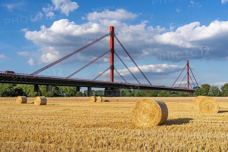 Grain field, harvested, straw bales, near Duisburg-Baerl, behind the motorway bridge of the A42 over the Rhine, Thyssenkrupp Steel steelworks in Duisburg-Beeckerwerht, North Rhine-Westphalia, Germany, Europe