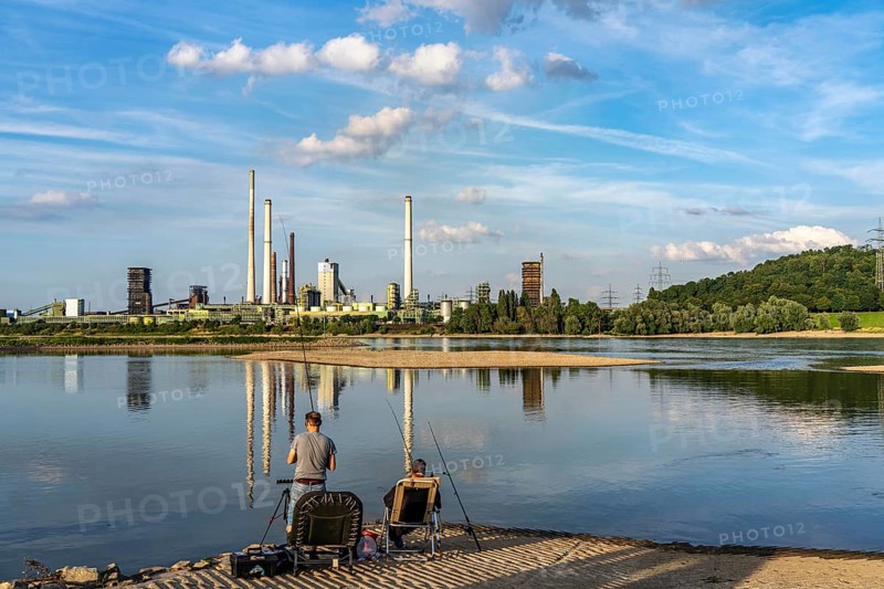 Industrial backdrop of the ThyssenKrupp Steel steelworks in Bruckhausen, on the Rhine, Schwelgern coking plant, anglers in a bay in the Rhine near Duisburg Bärl, Duisburg, North Rhine-Westphalia, Germany, Europe