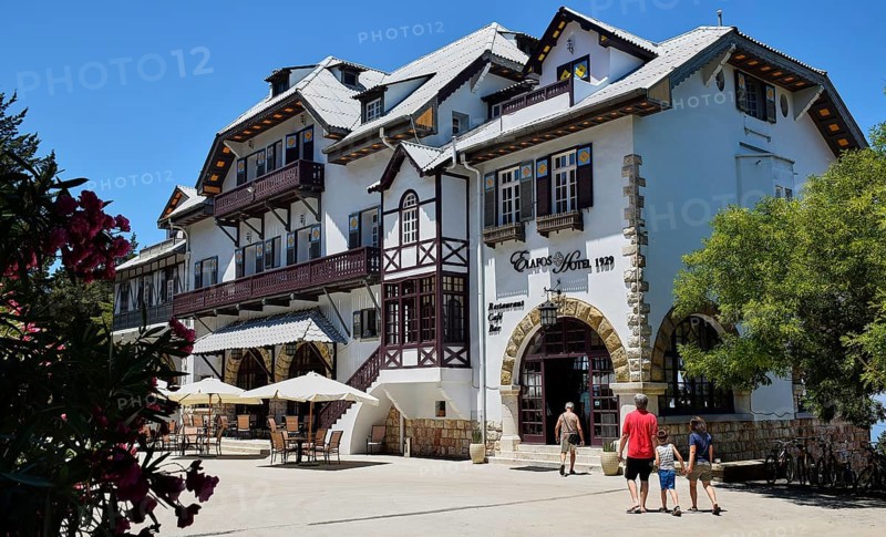 Historic white hotel with half-timbered houses, parasols and holidaymakers on a sunny day, Elafos Hotel, Profitis Ilias, Rhodes, Dodecanese, Greek Islands, Greece, Europe