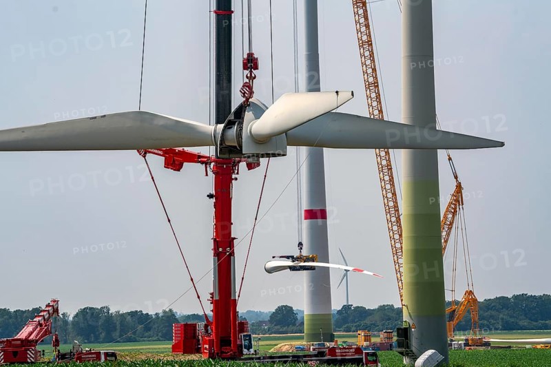 Dismantling of a wind power plant in a wind farm near Issum, 9 older wind turbines from the manufacturer Enercon (model series E-58), front, blades being dismantled, were in operation for over two decades, will be replaced by a total of four Enercon E-160 turbines, rear, assembly of the first blade, with a total output of 22 megawatts, Lower Rhine, North Rhine-Westphalia, Germany, Europe